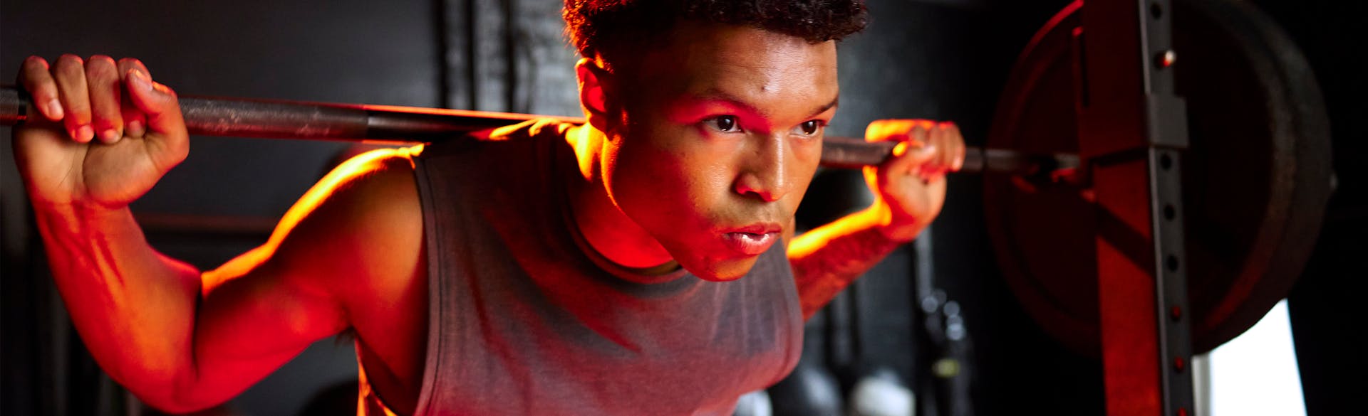 A man lifting a barbell on his shoulders